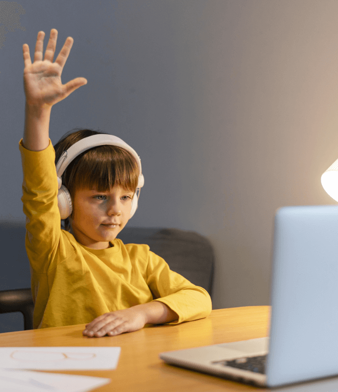 school-boy-yellow-shirt-taking-virtual-classes-raising-hand